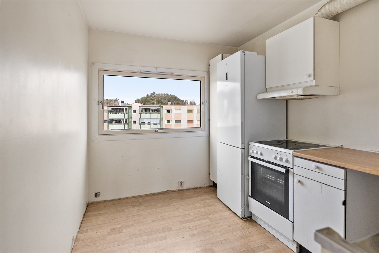 Kjøkken med laminat/parkett på gulvet, malte slette flater på vegger og i tak. Galleribilde