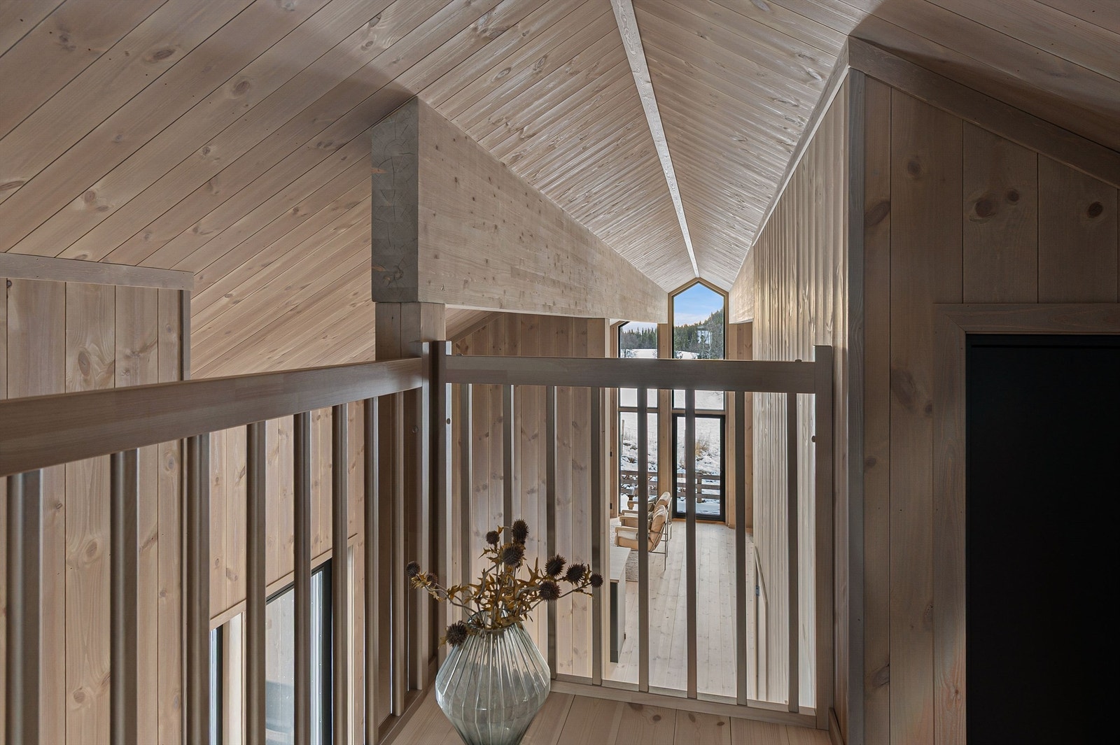 Fra hemsen har man utsyn over deler av stuen, noe som forsterker den åpne romfølelsen. Galleribilde