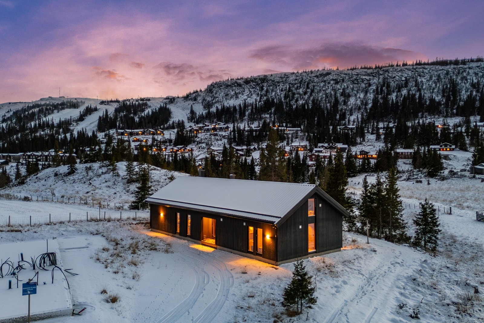 I kveldslyset ser man tydelig hyttas nærhet til skianlegget. Galleribilde
