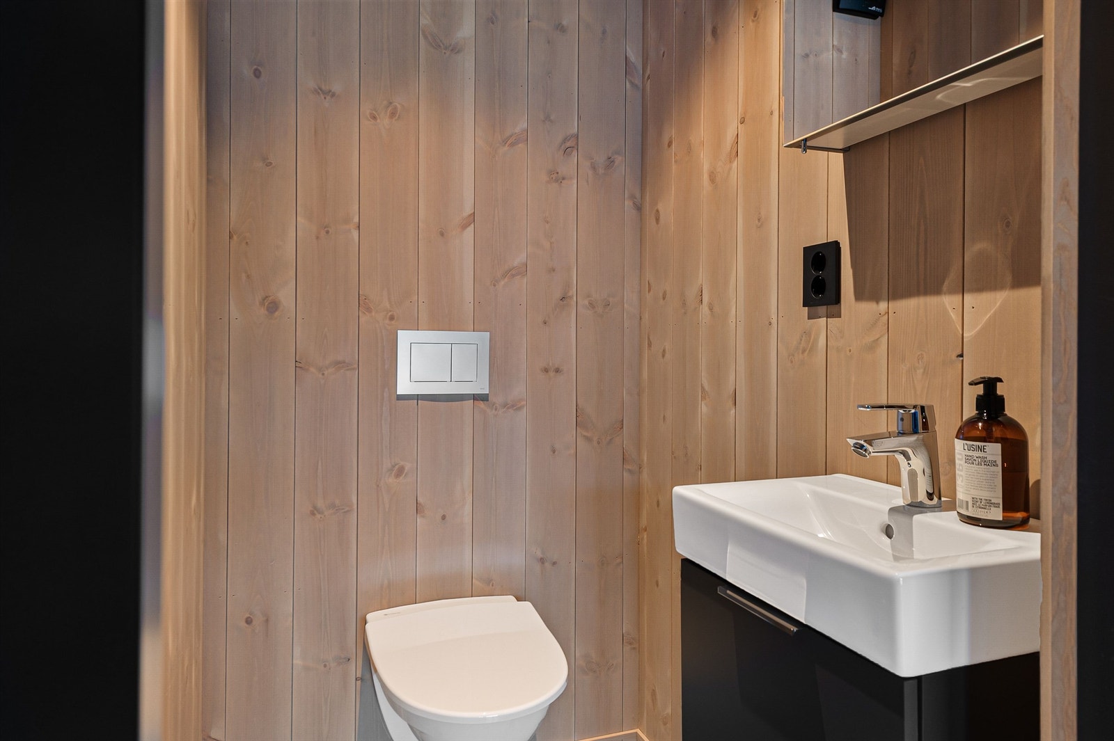 Et separat toalettrom med vegghengt toalett, servant og gulvvarme. Galleribilde