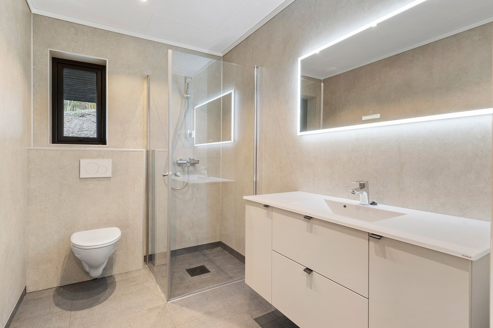 Ett av to bad med dusj, wc, innredning og varme i gulv Galleribilde