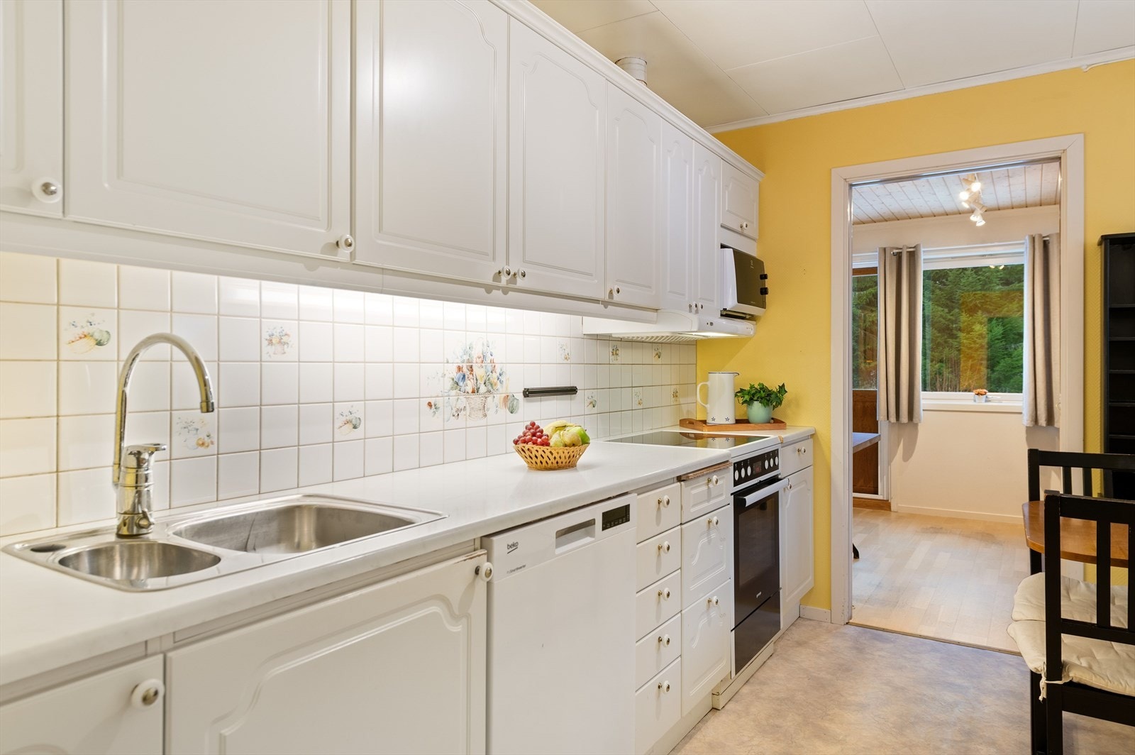 Kjøkkeninnredning med profilerte fronter i laminert tre og laminert benkeplate i tre. Galleribilde