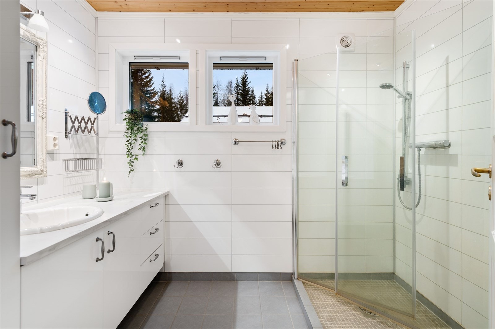 Bad med fliser på gulv, baderomsplater på vegg og panel i himling. Galleribilde