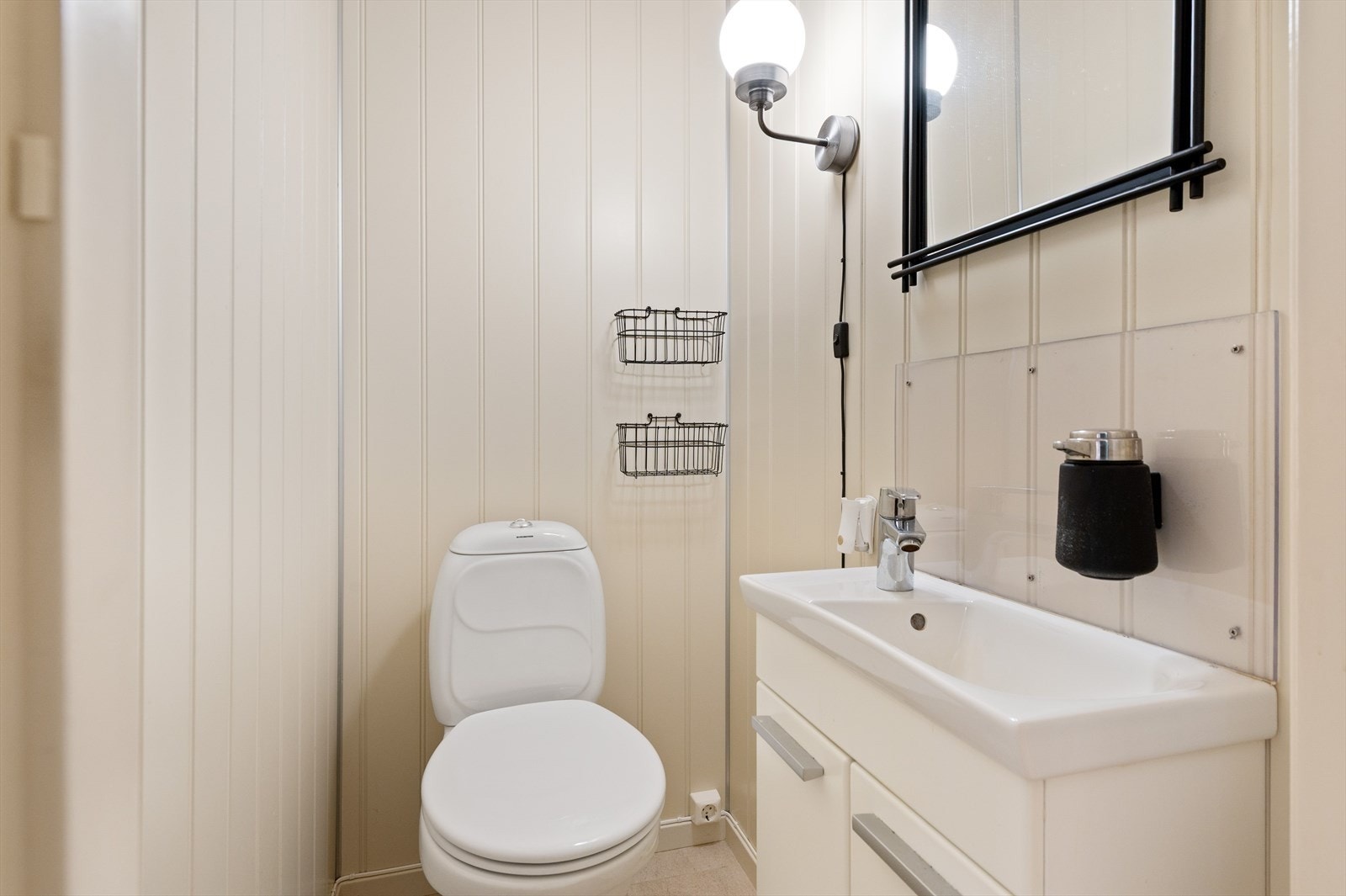 Toalettrom med fliser på gulv, panel på vegg og panel i himling. Galleribilde