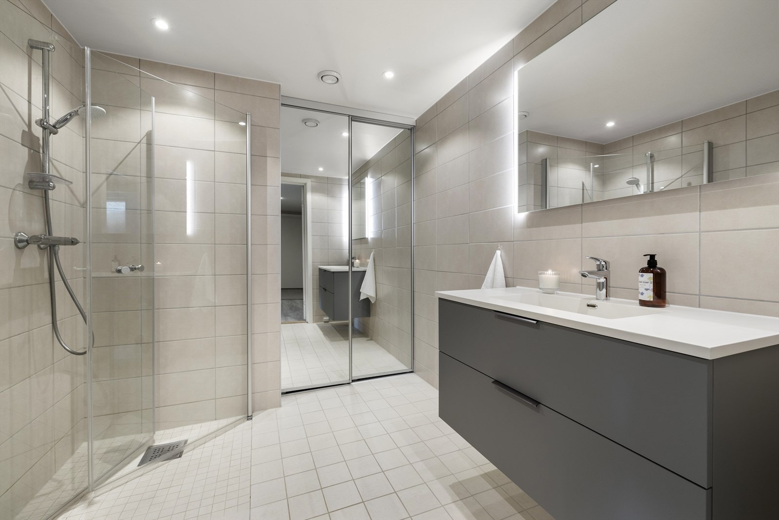 Det er opplegg for vaskemaskin og tørketrommel som er skjult bak skyvedører av speil. Galleribilde