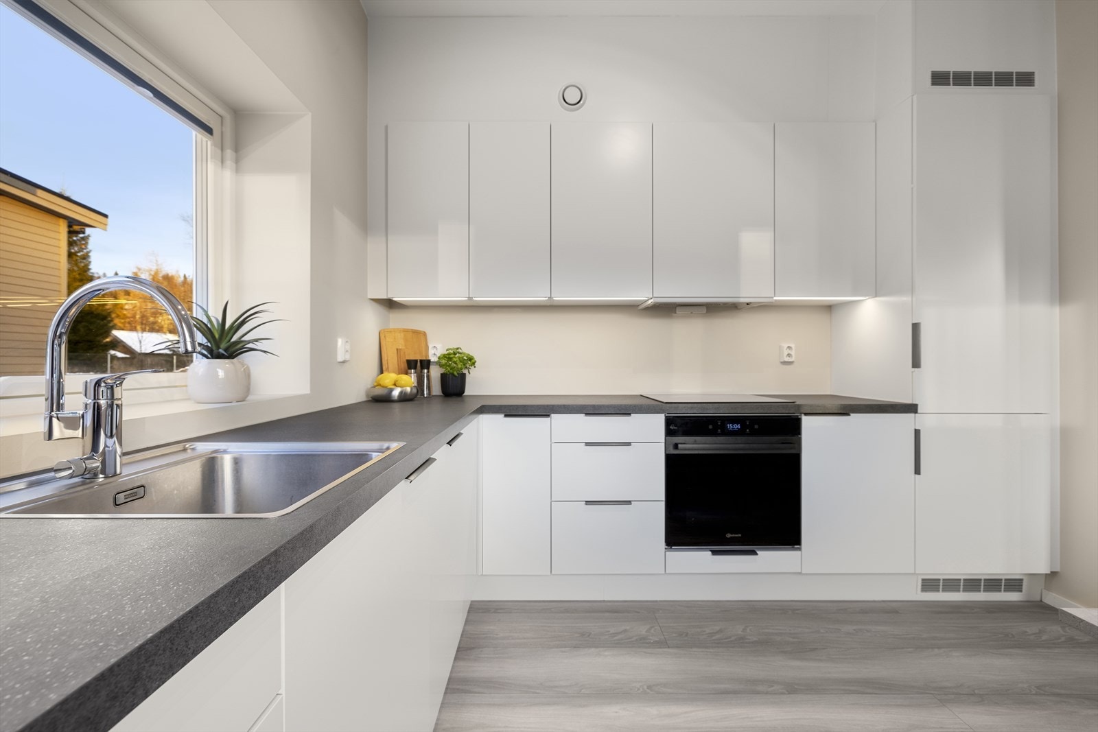 Innredningen har glatte fronter og laminat benkeplate med nedfelt stålvask med ett-greps blandebatteri. Galleribilde