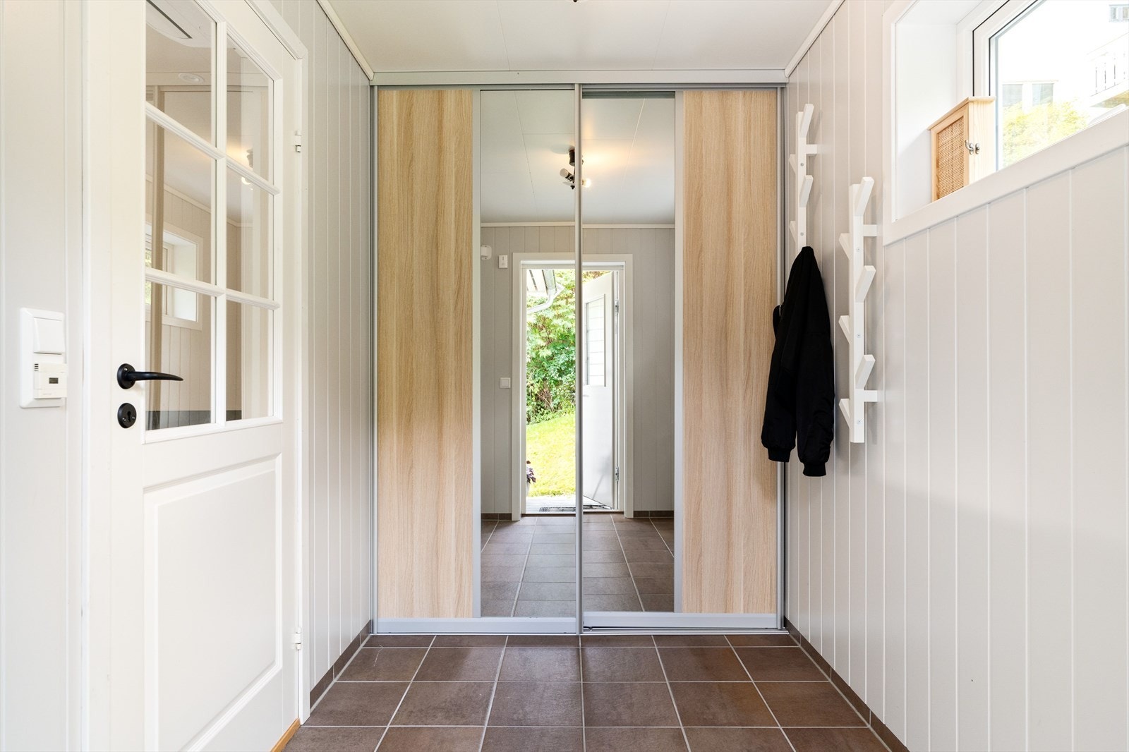 Her er det god plass til oppbevaring av sko og yttertøy, og en praktisk skyvedørsgarderobe sørger for effektiv utnyttelse av arealet. Galleribilde