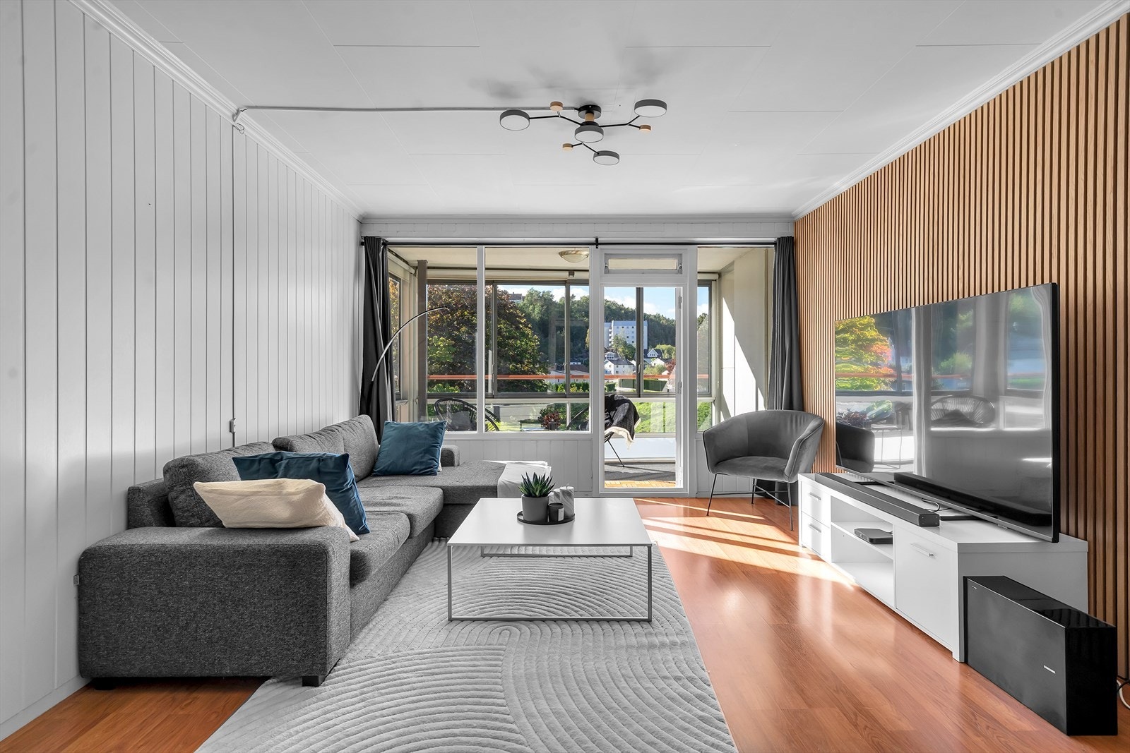 Den stilige spileveggen tilfører rommet et moderne og eksklusivt preg, mens de store vindusflatene slipper inn rikelig med naturlig lys som skaper en lys og luftig romfølelse. Galleribilde