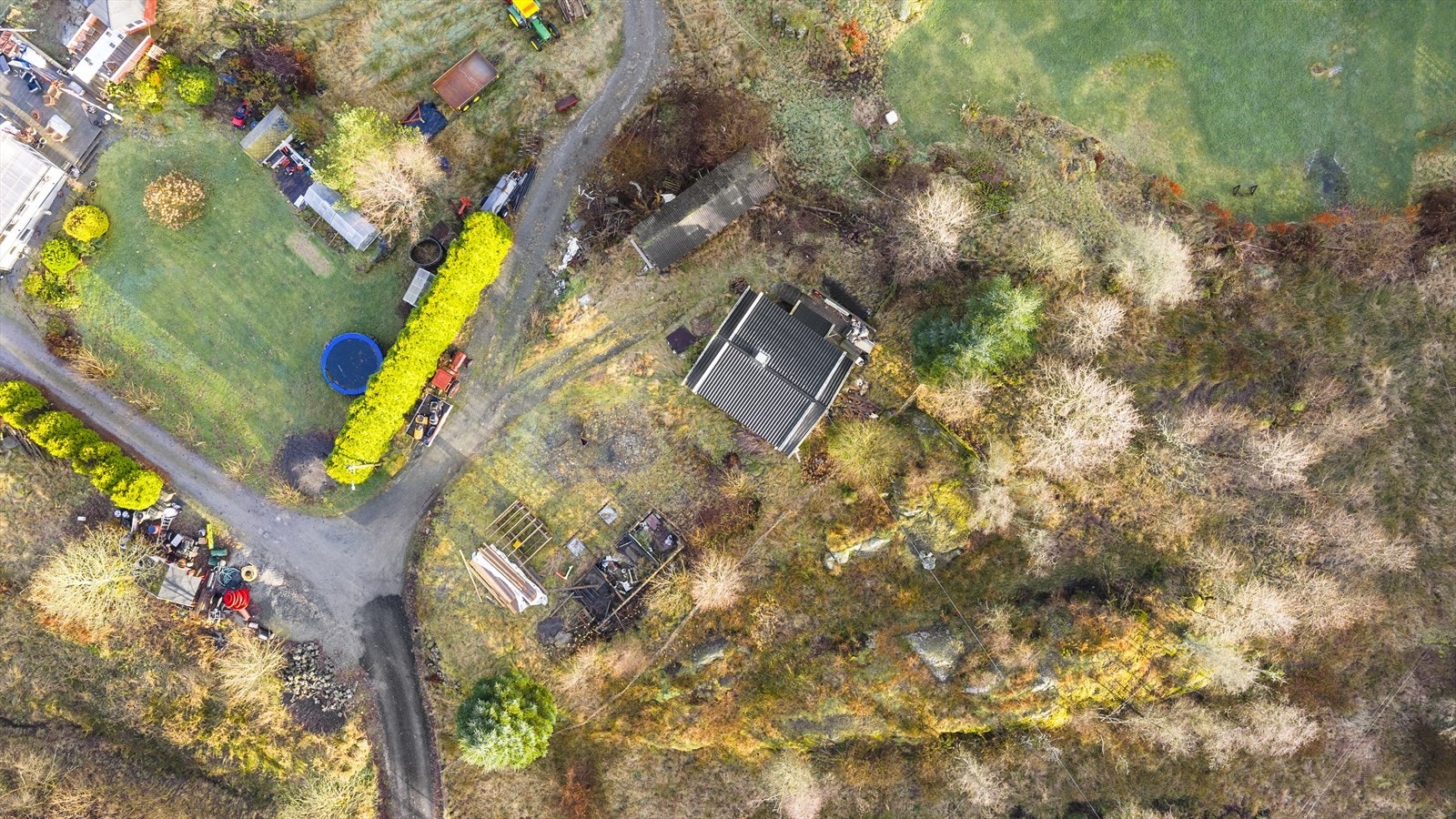 Eiendommen har en tomt på 880,9 kvm som er opparbeidet med plen, noe beplantning og gruset innkjørsel Galleribilde