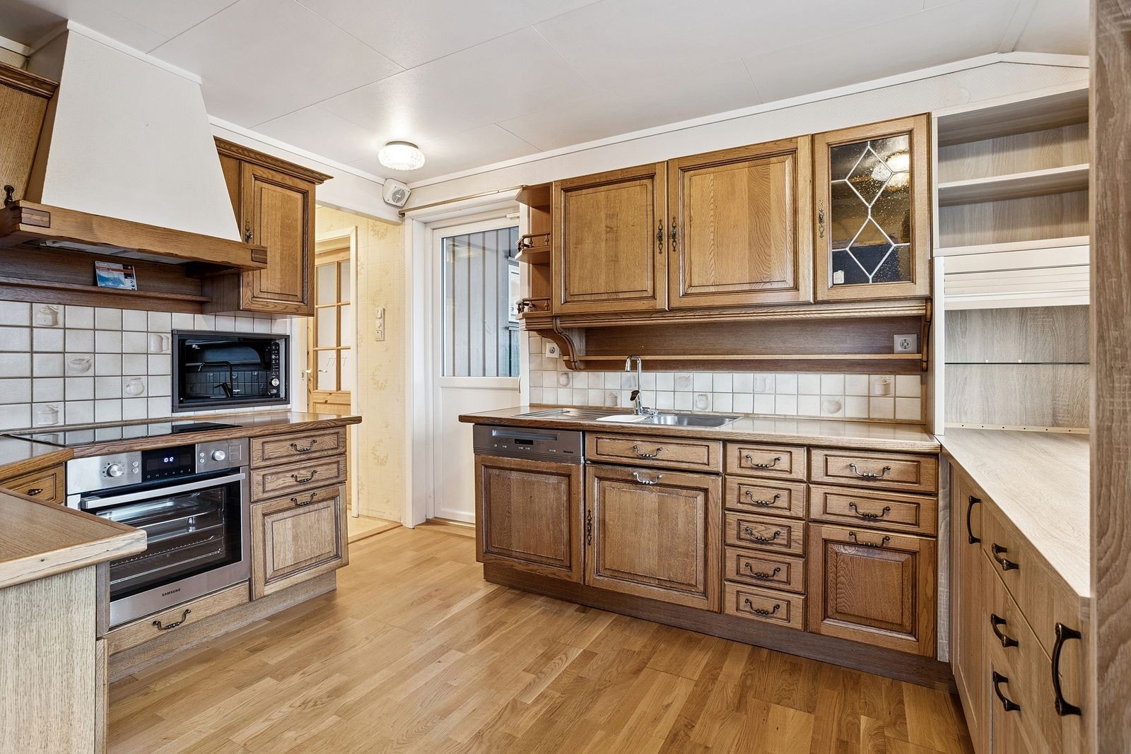 Kjøkkenet inneholder komfyr, steketopp, oppvaskemaskin, kjøleskap, mikro og stor fryser. Galleribilde