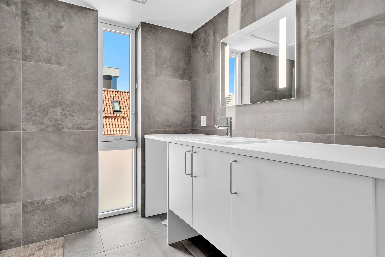 Badet har også opplegg til vaskemaskin og lys i speilet over baderomsmøbelet. Galleribilde