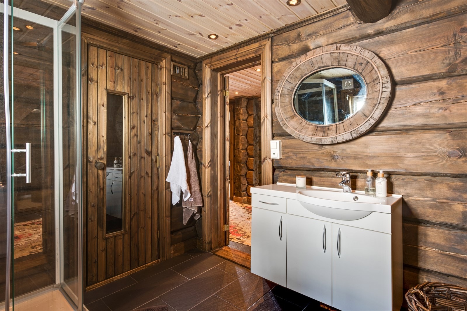 Bad innredet med dusjkabinett, toalett og baderomsinnredning. Flisbelagt gulv med varmekabler. Tilkomst til badstue. Opplegg for vaskemaskin. Galleribilde