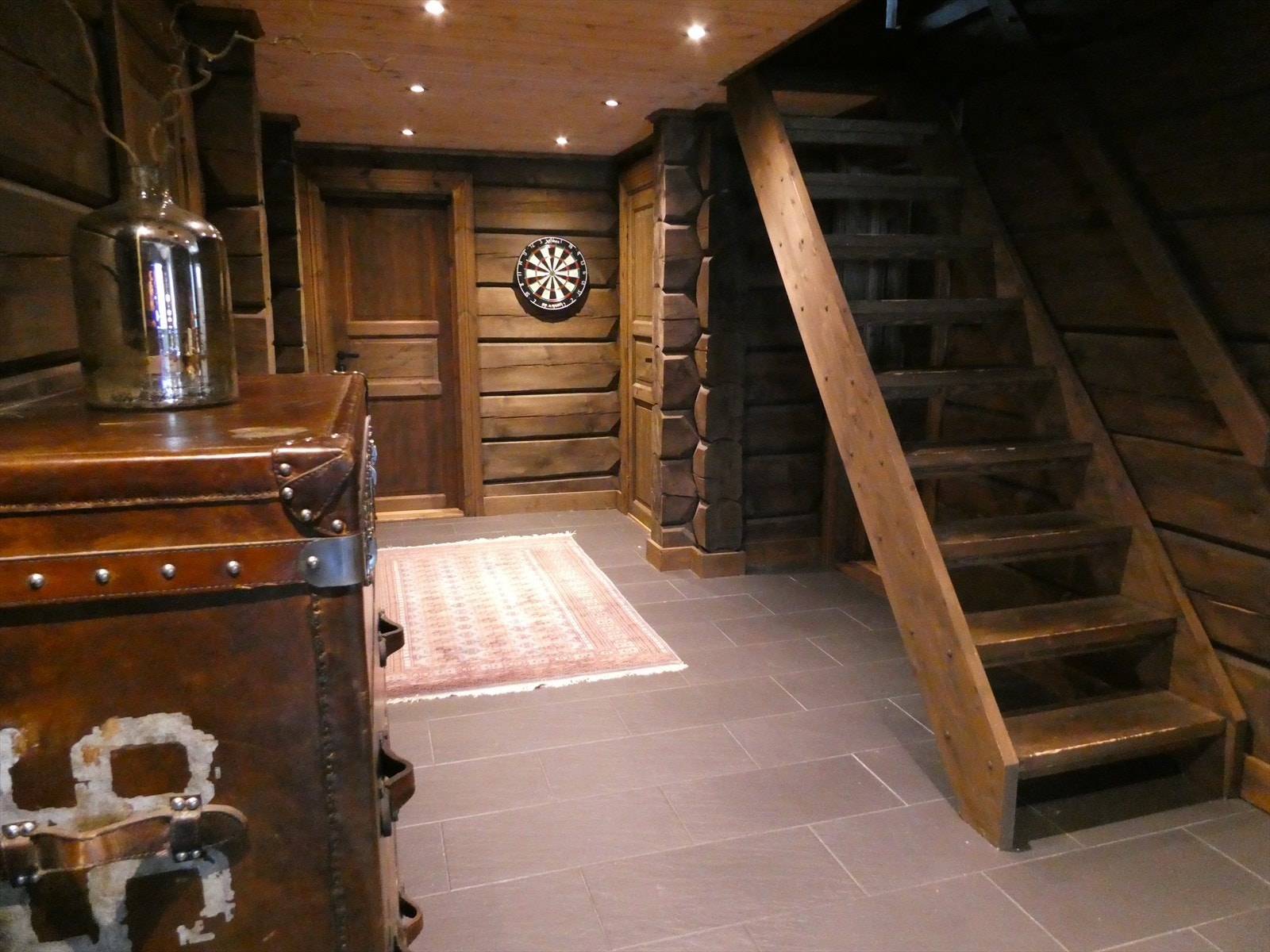 Gangen er belagt med flis med varmekabler på gulv. Gjennomgående vegger av laftet tømmer. Galleribilde