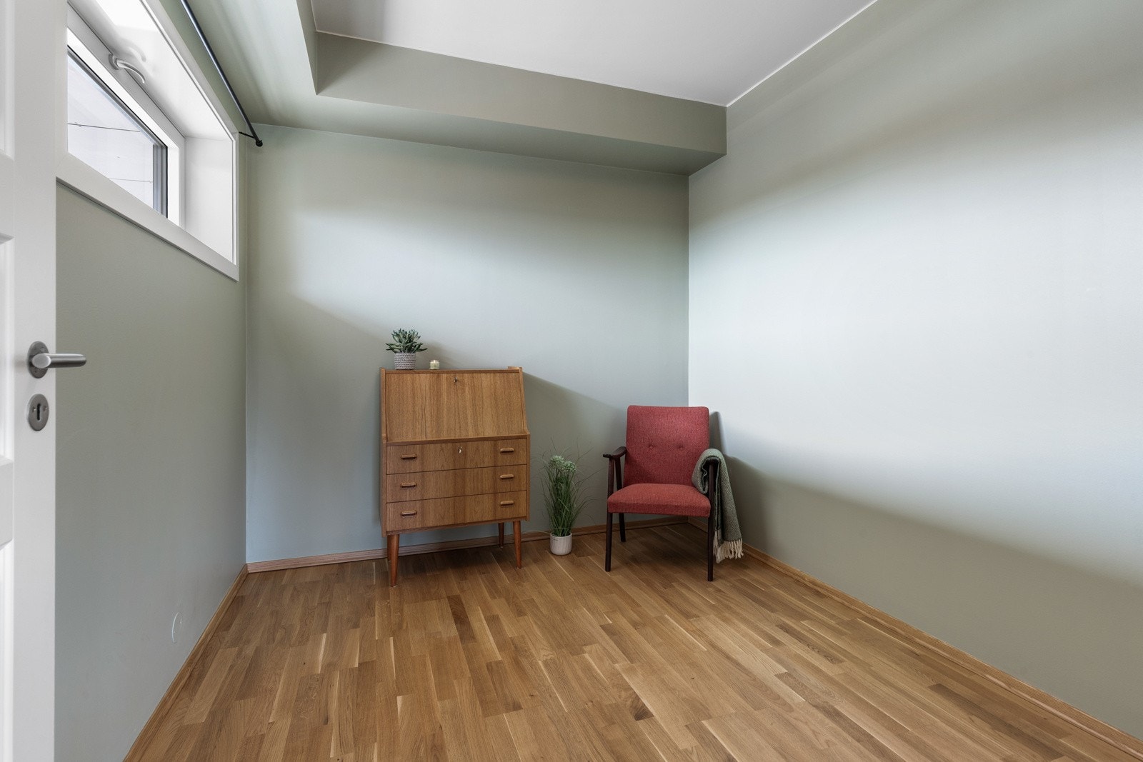 Kontoret/gjestermmet har lyse vegger, parkettgulv og et vindu som slipper inn naturlig lys. Galleribilde