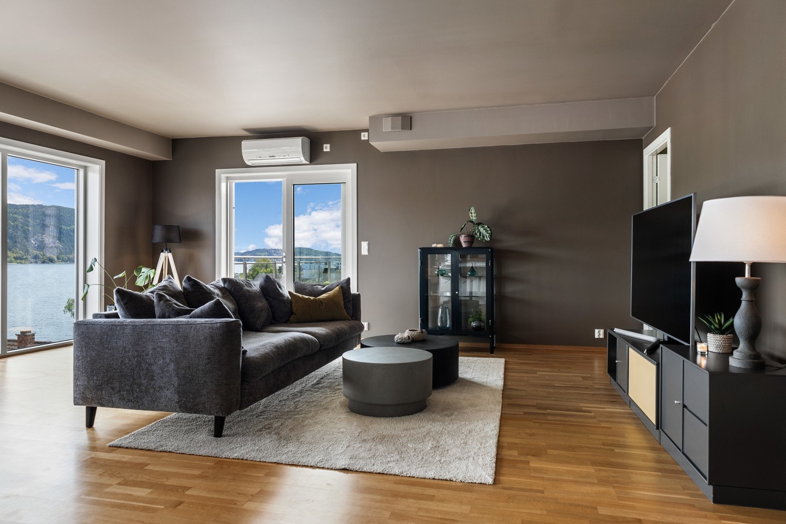 Romslig stue med store vinduer og utsikt mot vannet. Galleribilde