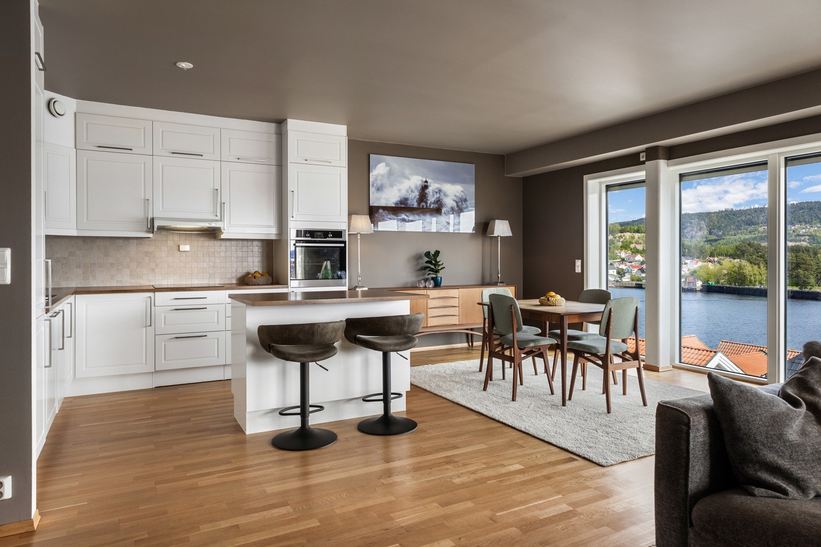 Lys og åpen kjøkken- og stueløsning med utsikt mot fjorden. Galleribilde