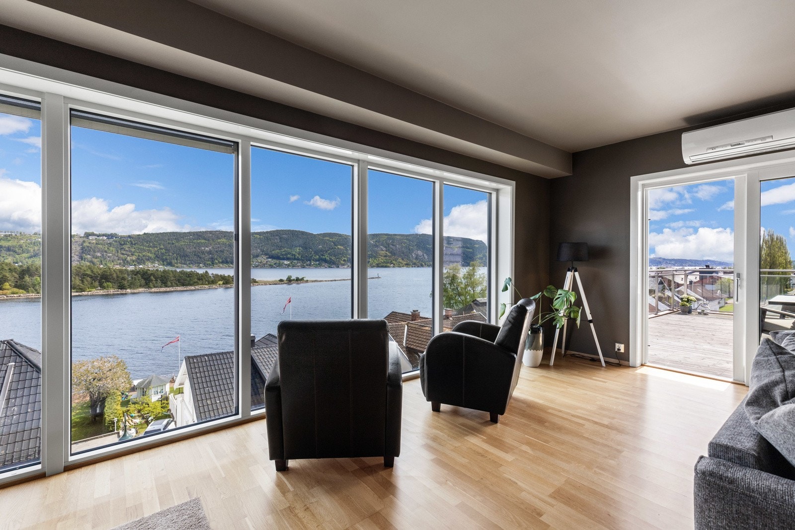 Romslig stue med store vinduer og fantastisk utsikt over fjorden og omkringliggende natur. Galleribilde