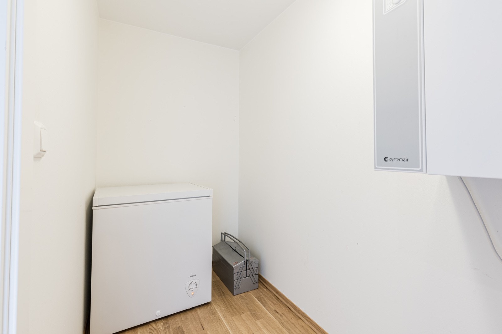 Teknisk rom med fryseboks, ventilasjonssystem og parkettgulv. Galleribilde