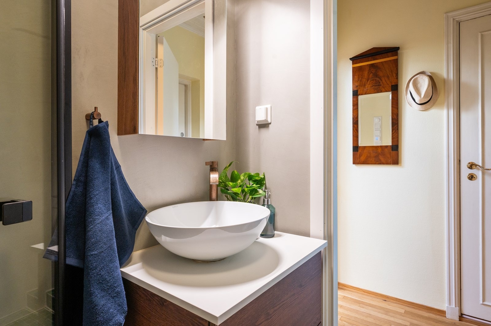 Innredningen består av vegghengt toalett, servant med blandebatteri, speilskap og kobberdetaljer fra Bad.no, samt et praktisk veggskap som gir ekstra oppbevaringsplass. Galleribilde