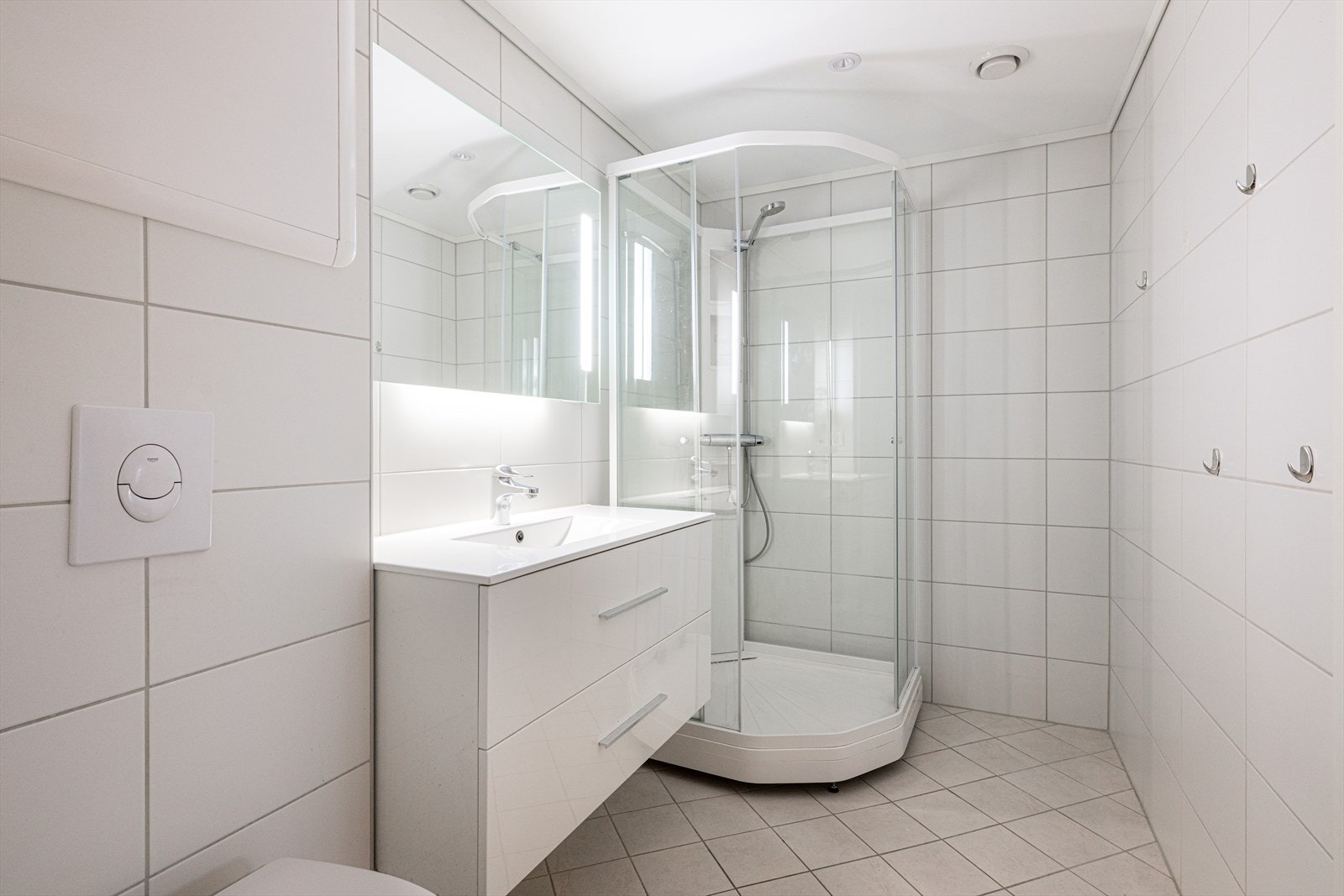 Pent, flislagt bad pusset opp i regi av borettslaget i 2019. Badet har elektriske varmekabler, veggmontert toalett og dusjkabinett, samt innfelte spotter i tak. Galleribilde