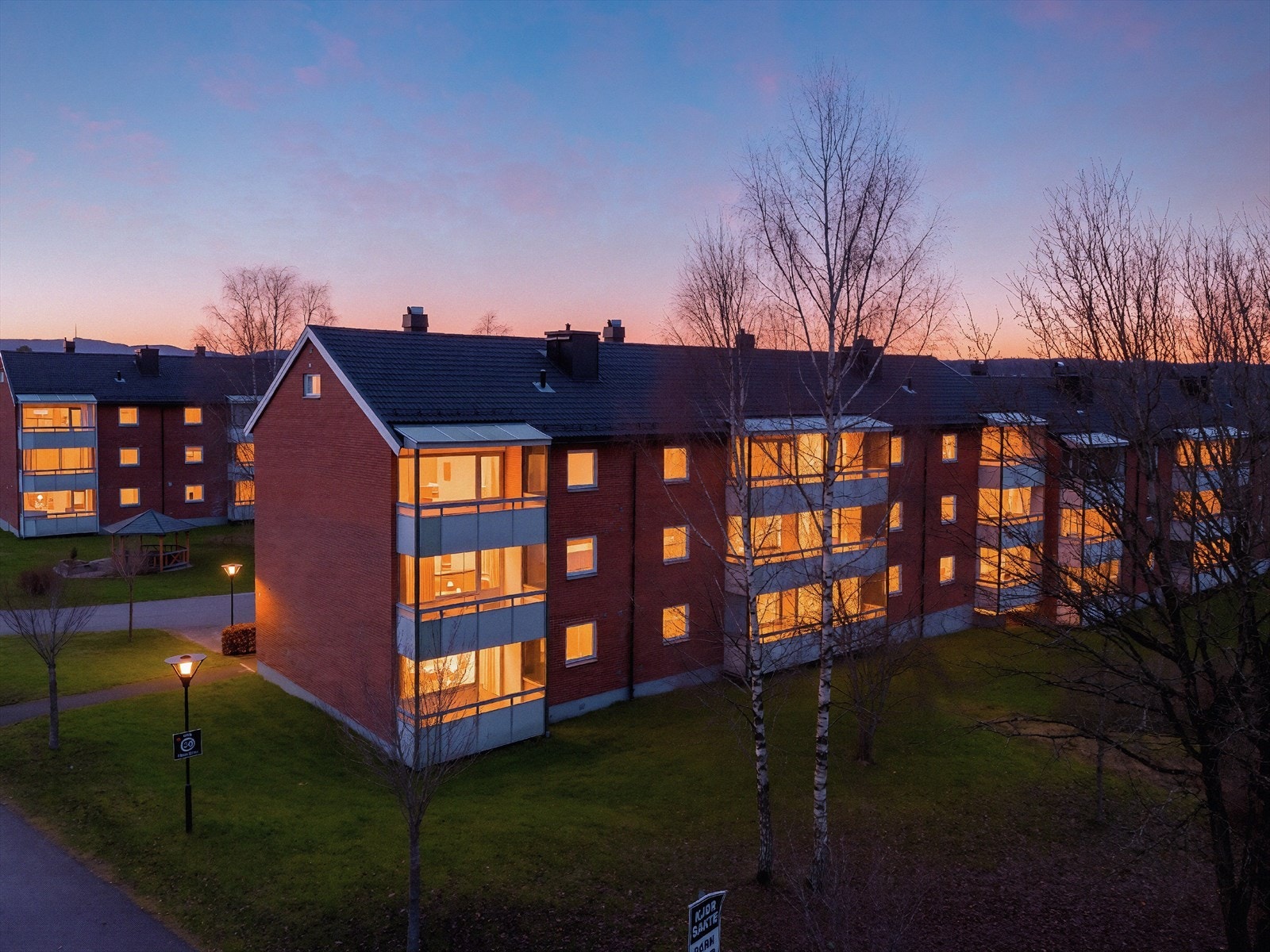 Borettslaget har flere sosiale soner og en nyere lekeplass fra 2014. Bildet er redigert for å fremheve stemningen på kveldstid. Faktiske lysforhold kan variere. Galleribilde