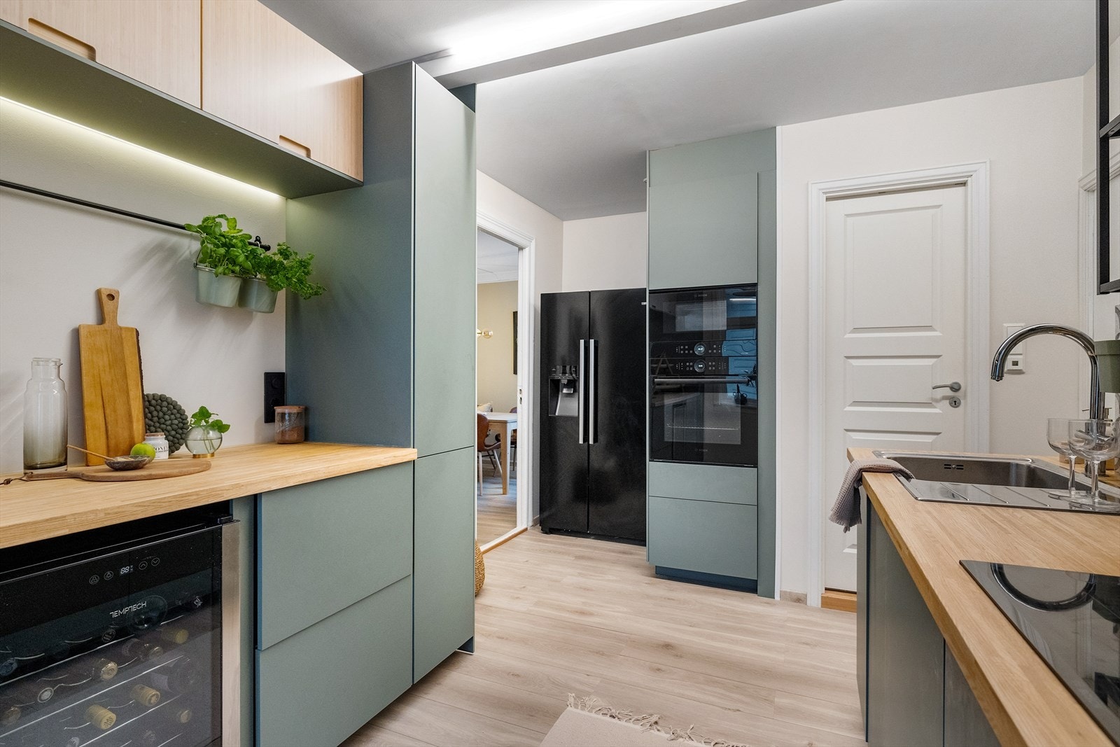 Her er det gode hvitevarer med vannkoker i springen, vinskap og side-by-side kjøleskap. Galleribilde