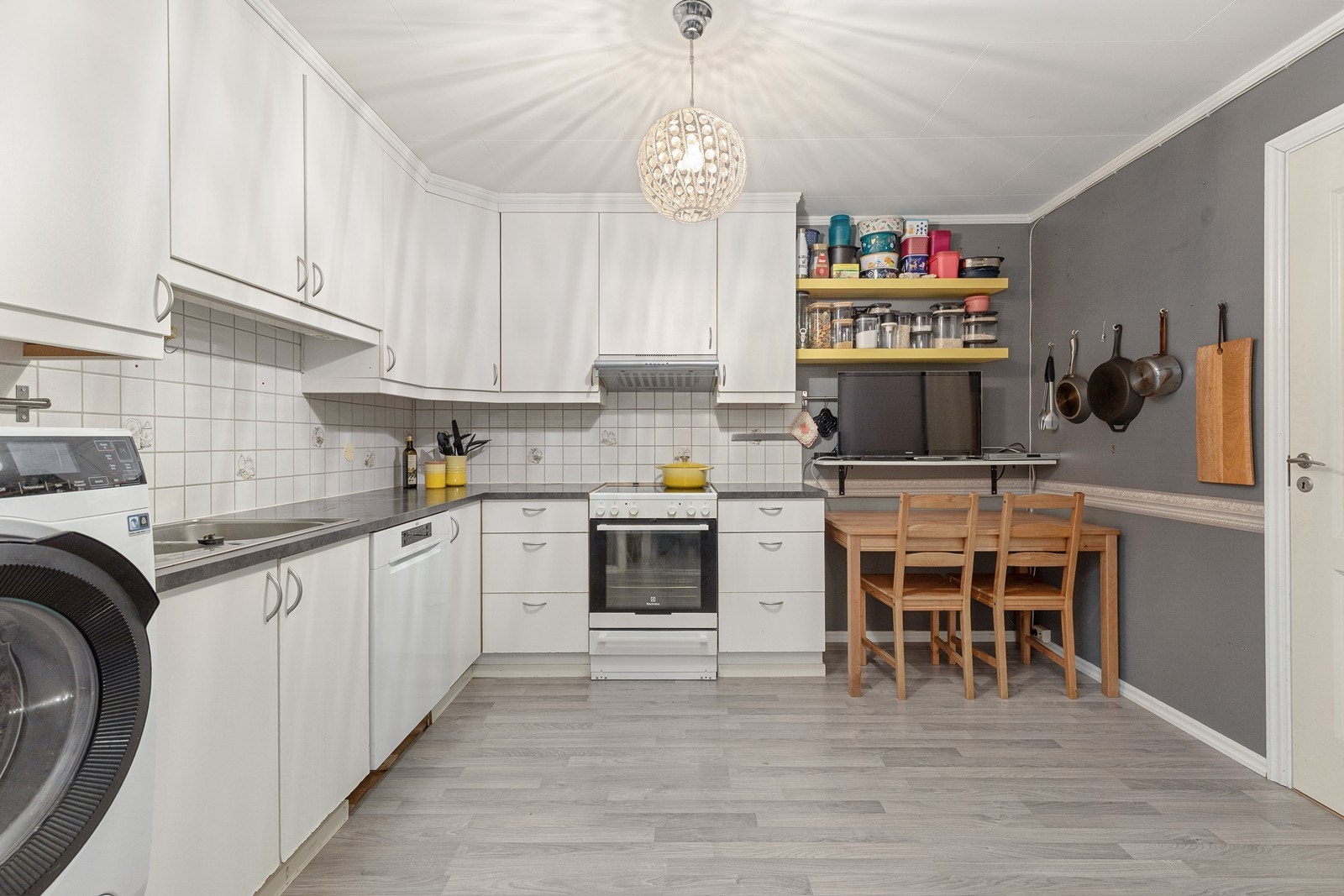 Romsleg kjøkken med innreiing i glatt utføring og benkeplate i laminat. Galleribilde