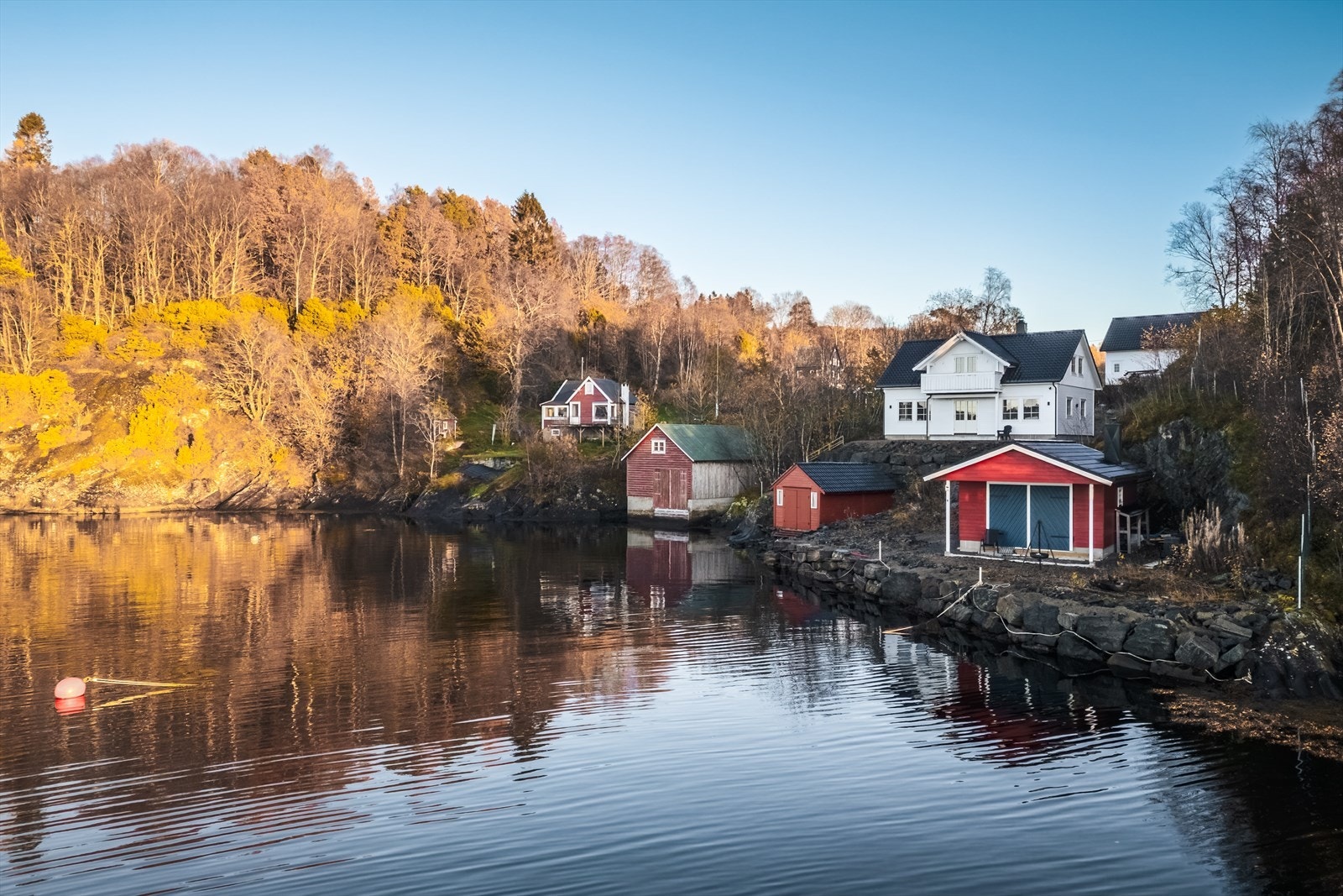 Boligens tilhørende naust ligger bare noen meter lengre nede i gaten, og er det man ser i midten av bildet Galleribilde