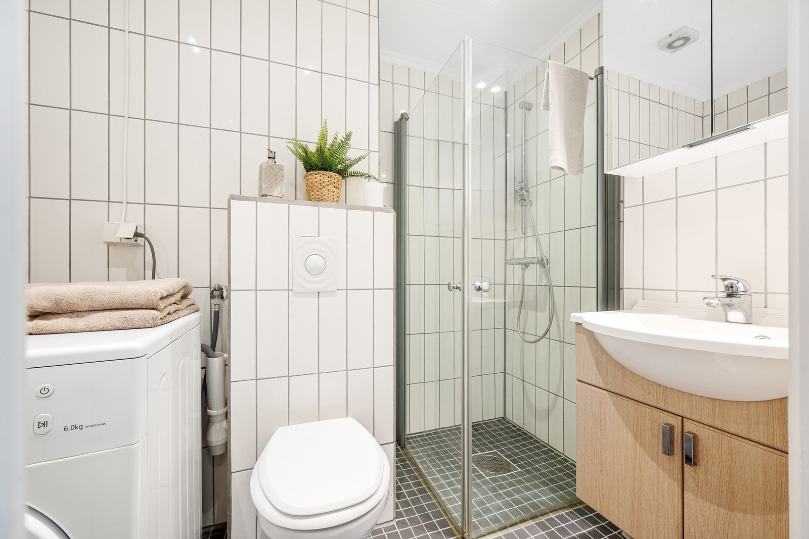 Pent flislagt baderom fra 2007 med opplegg for vaskemaksin og tørketrommel. Galleribilde