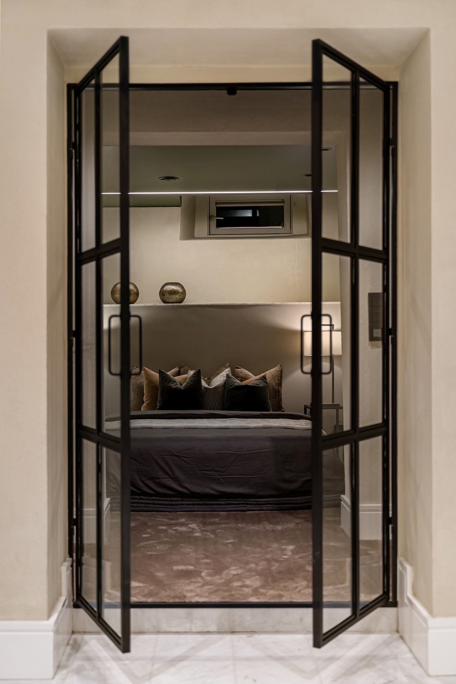 Tiltalende hovedsoverom med vannbåren varme, vegg-til-vegg-teppe og stilrene smijernsdører. Galleribilde