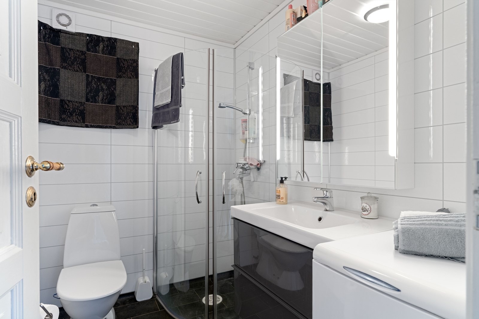 Badet i sokkel er oppgradert i 2015 og fremstår lyst og moderne, med belegg på gulv og våtromsplater på vegger. Galleribilde