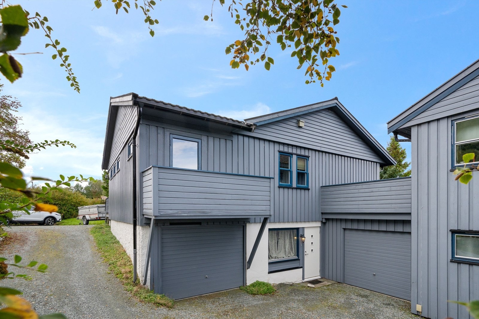 Pent opparbeidet gårdsplass foran huset med plass til flere biler, kombinert med to integrerte garasjer. Galleribilde