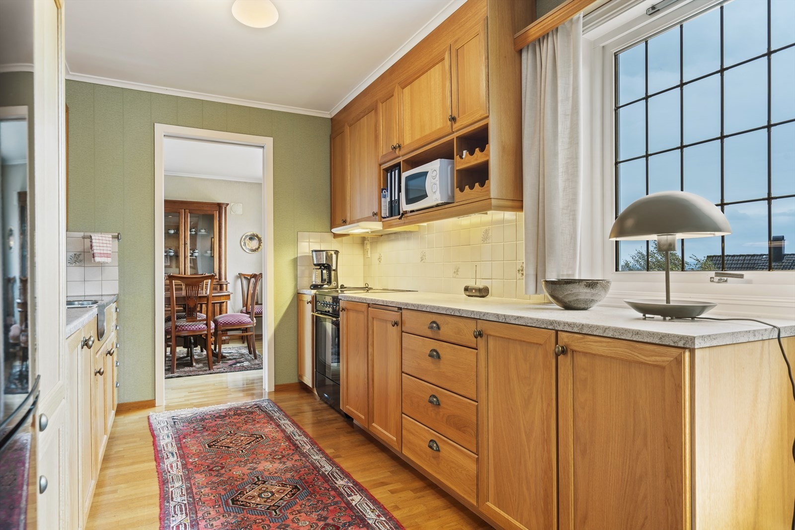 Kjøkken har parkett på gulv, tapet på vegger, fliser o/kjøkkenbenk. God spiseplass, alle hvitevarer følger salget. Galleribilde