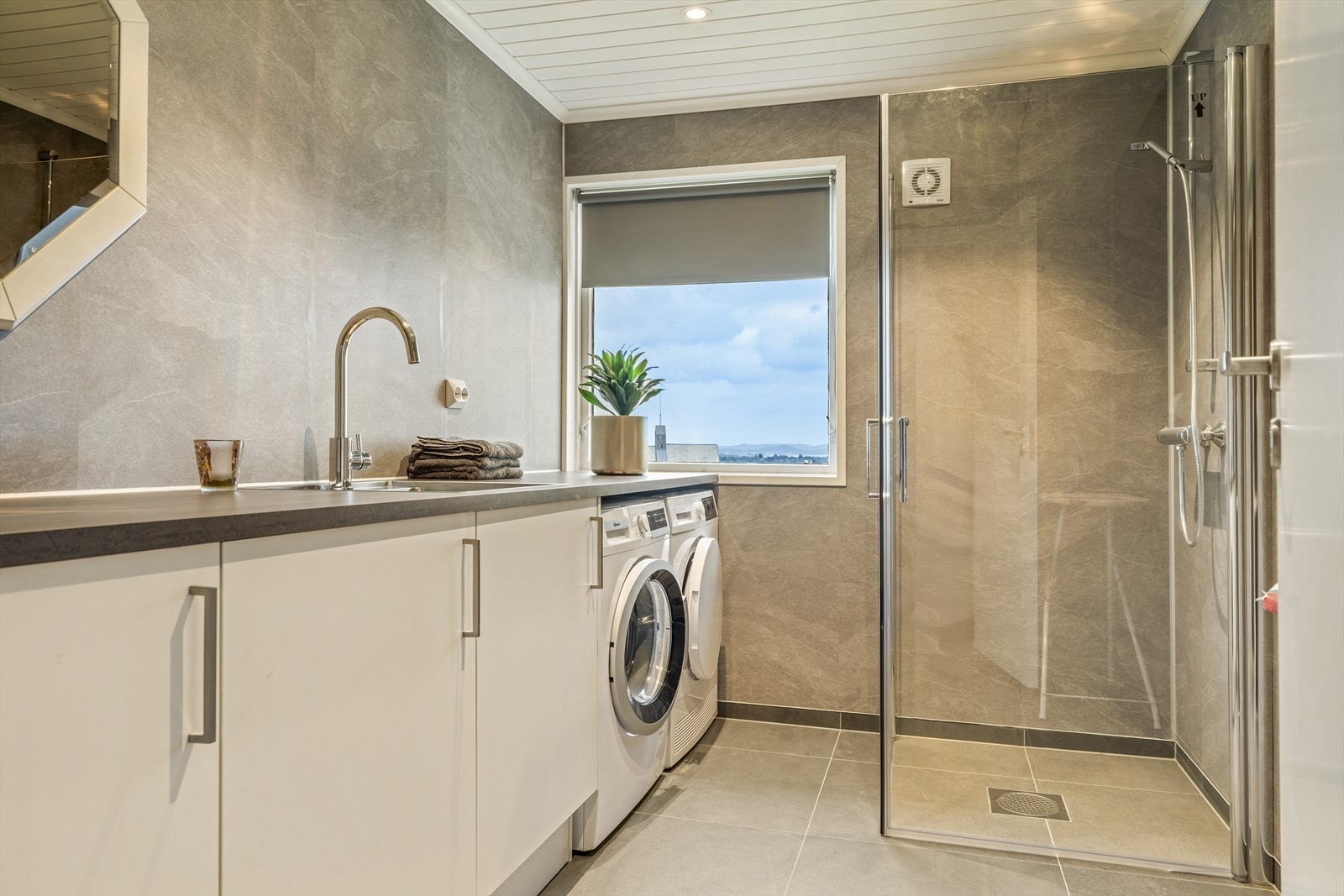 Vaskerom/ dusj har fliser på gulv, våtromsplater på vegger. Opplegg vaskemaskin, arbeidsbenk, dusjhjørne, varme i gulv. Galleribilde