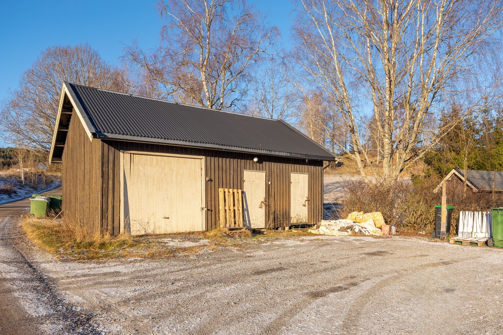 På inngangssiden har huset en gruslagt gårdsplass med mulighet for parkering. Gårdsplassen binder boligen sammen med et frittstående uthus. Galleribilde