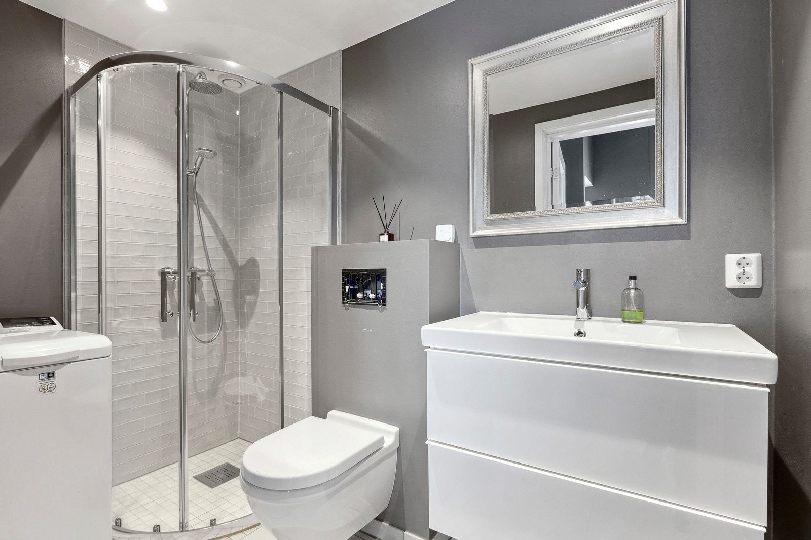 Pent flislagt bad med vaskemaskin. Galleribilde