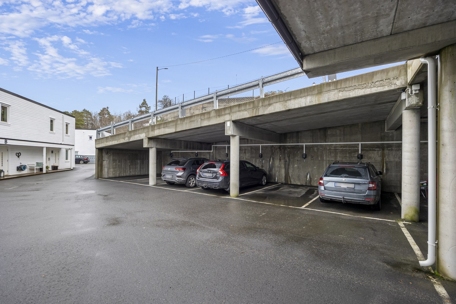 Parkeringsplass i carport med elbillader. Galleribilde