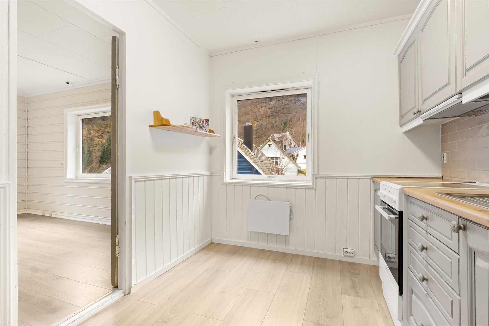 Kjøkkenet er praktisk innredet med profilerte fronter, laminert benkeplate, fliser over benk og stål oppvaskkum. Galleribilde