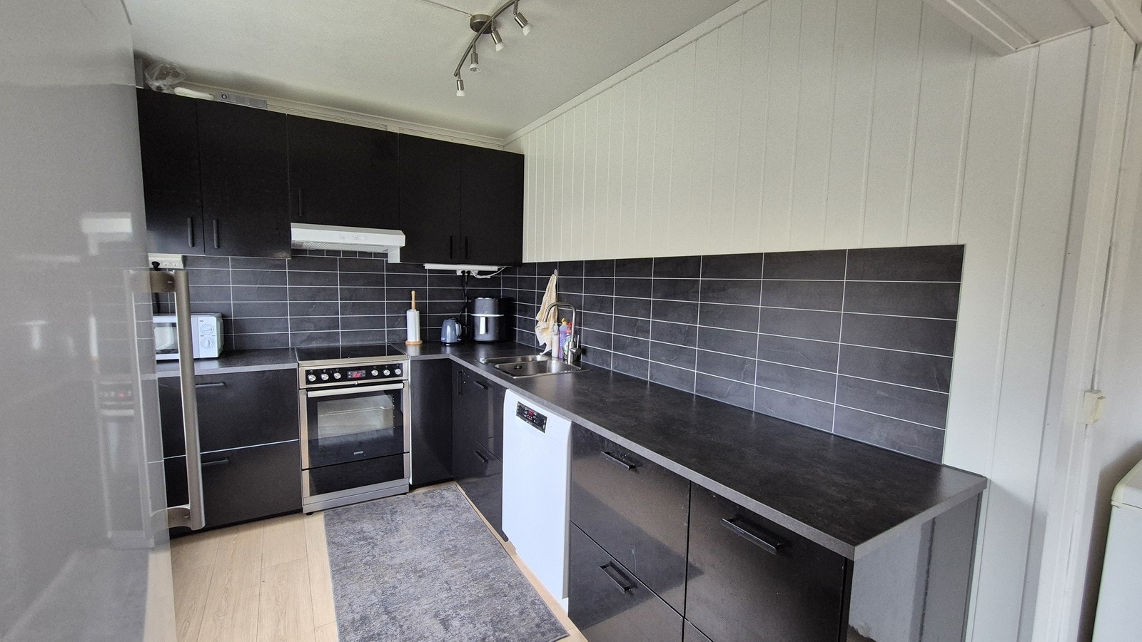 Kjøkken med noe nyere innredning og hvitevarer. Galleribilde