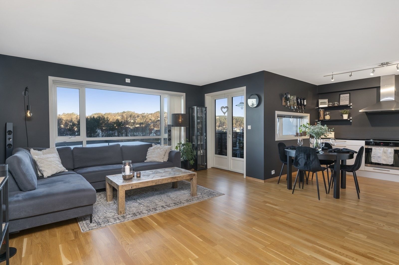 En stilfull stue med åpen løsning mot kjøkkenet. Store vinduer og utgang til balkong. Galleribilde