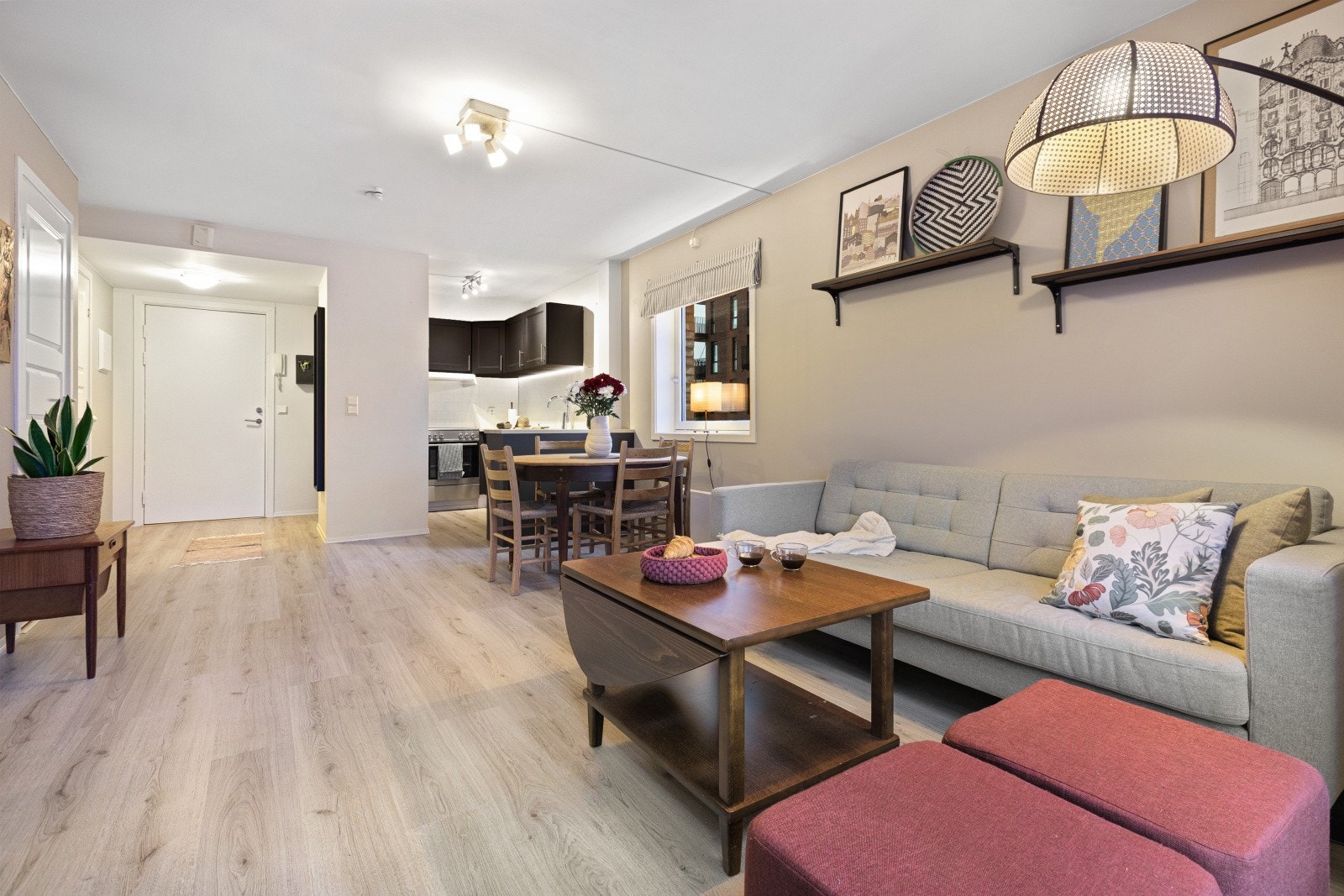 Den åpne løsningen mellom stue og kjøkken skaper en naturlig flyt i rommet og legger til rette for både hyggelige sosiale sammenkomster og praktiske hverdagsaktiviteter. Galleribilde