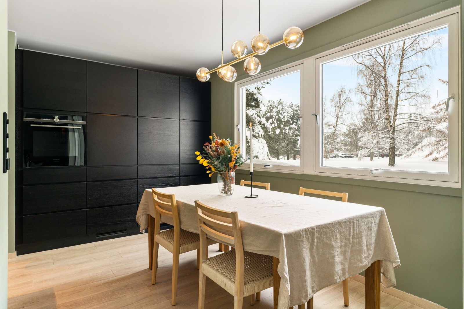 Kjøkkenet kombinerer estetikk og funksjonalitet på en gjennomført måte, med slette fronter og integrerte håndtak som gir et rent og moderne uttrykk. Galleribilde