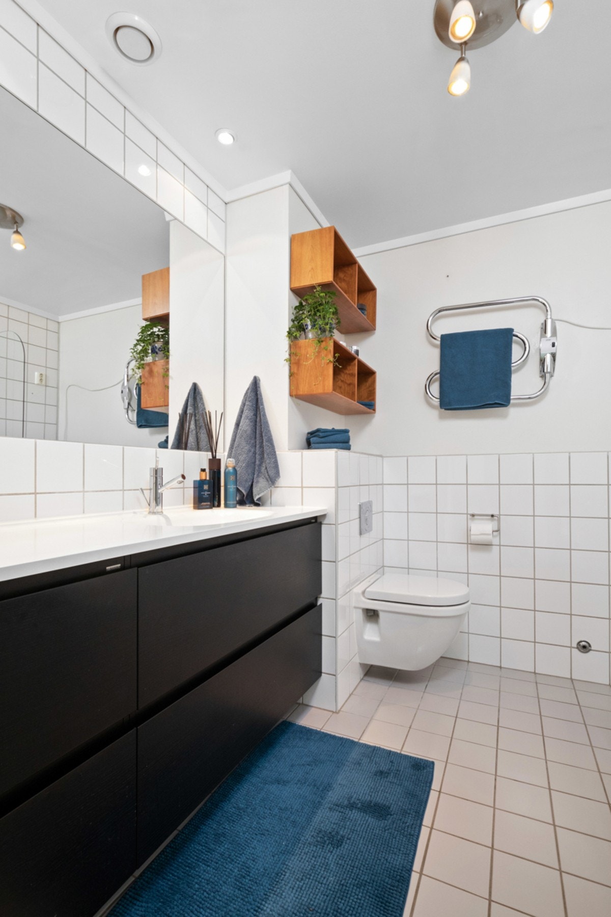 Det er badekar med regnfall og hånddusj, vegghengt toalett, elektrisk håndkletørker og opplegg for vaskemaskin. Galleribilde