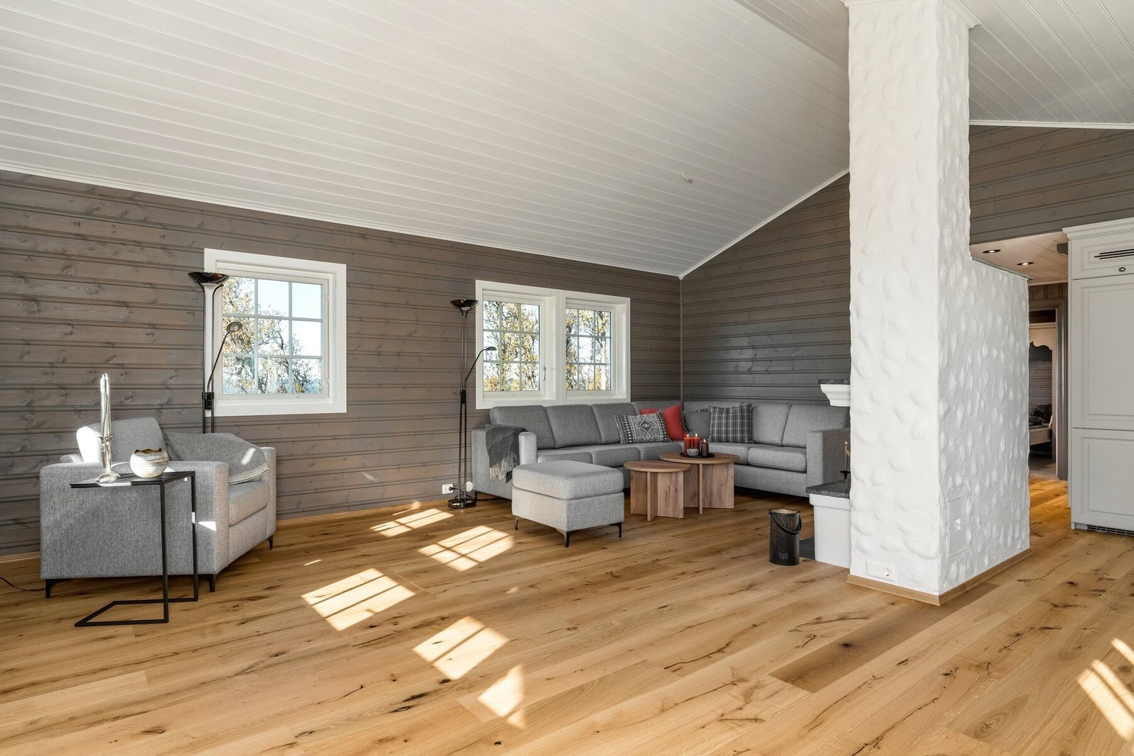 Lys og innbydende stue med mønet himling og mange vinduer som gir godt lysinnslipp. Galleribilde