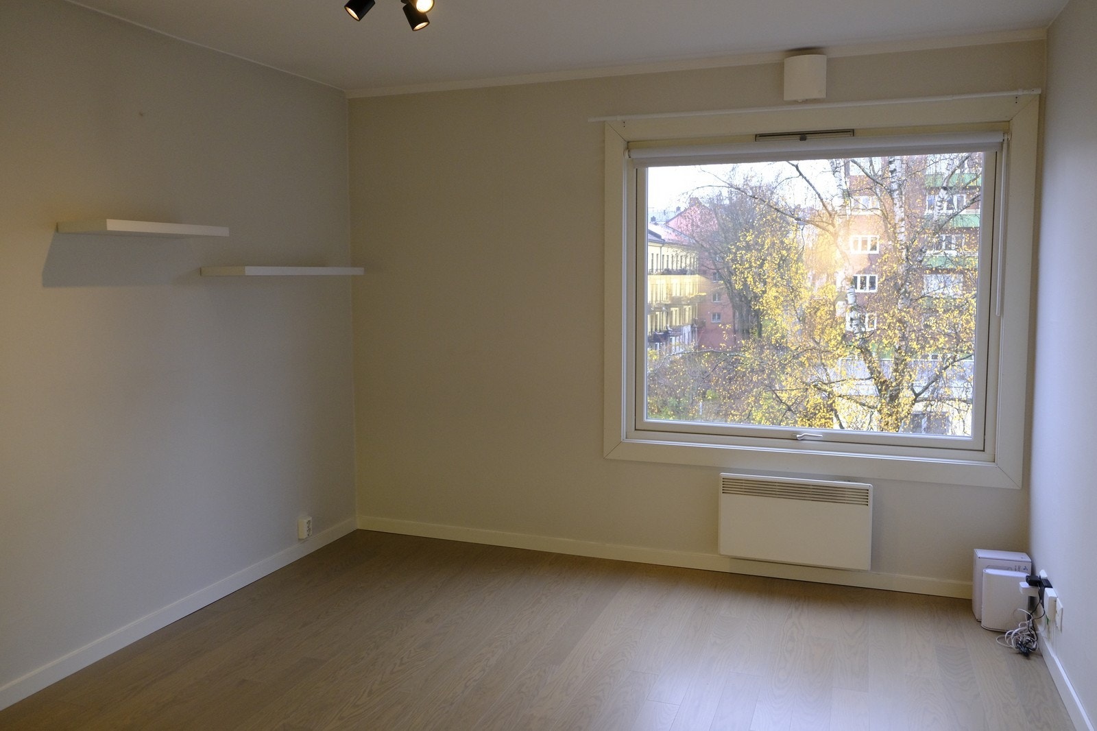 Stue med stort vindu som vender mot bakgård. Galleribilde