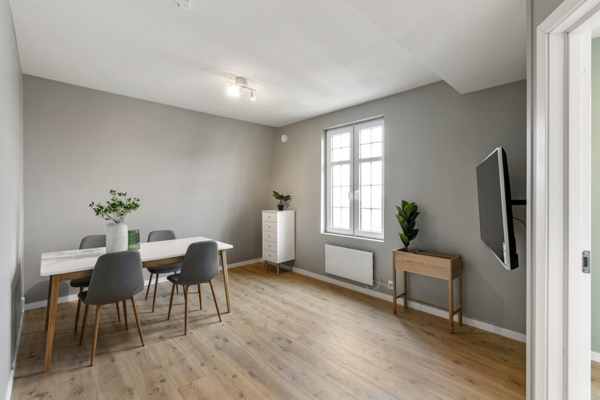 Stuen har i dag en stor sofa sammen med spisebord og stoler Galleribilde