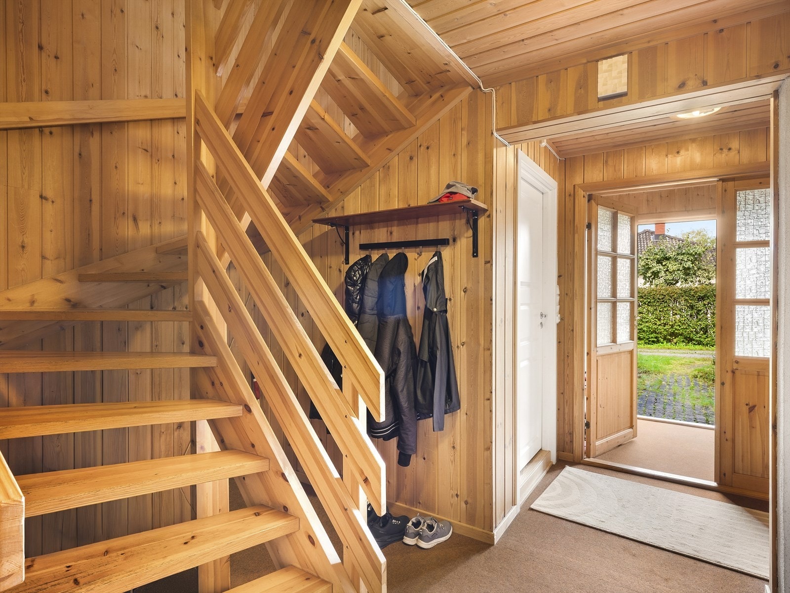 Innbydende entré med lakkert tretrapp som binder etasjene sammen. Galleribilde