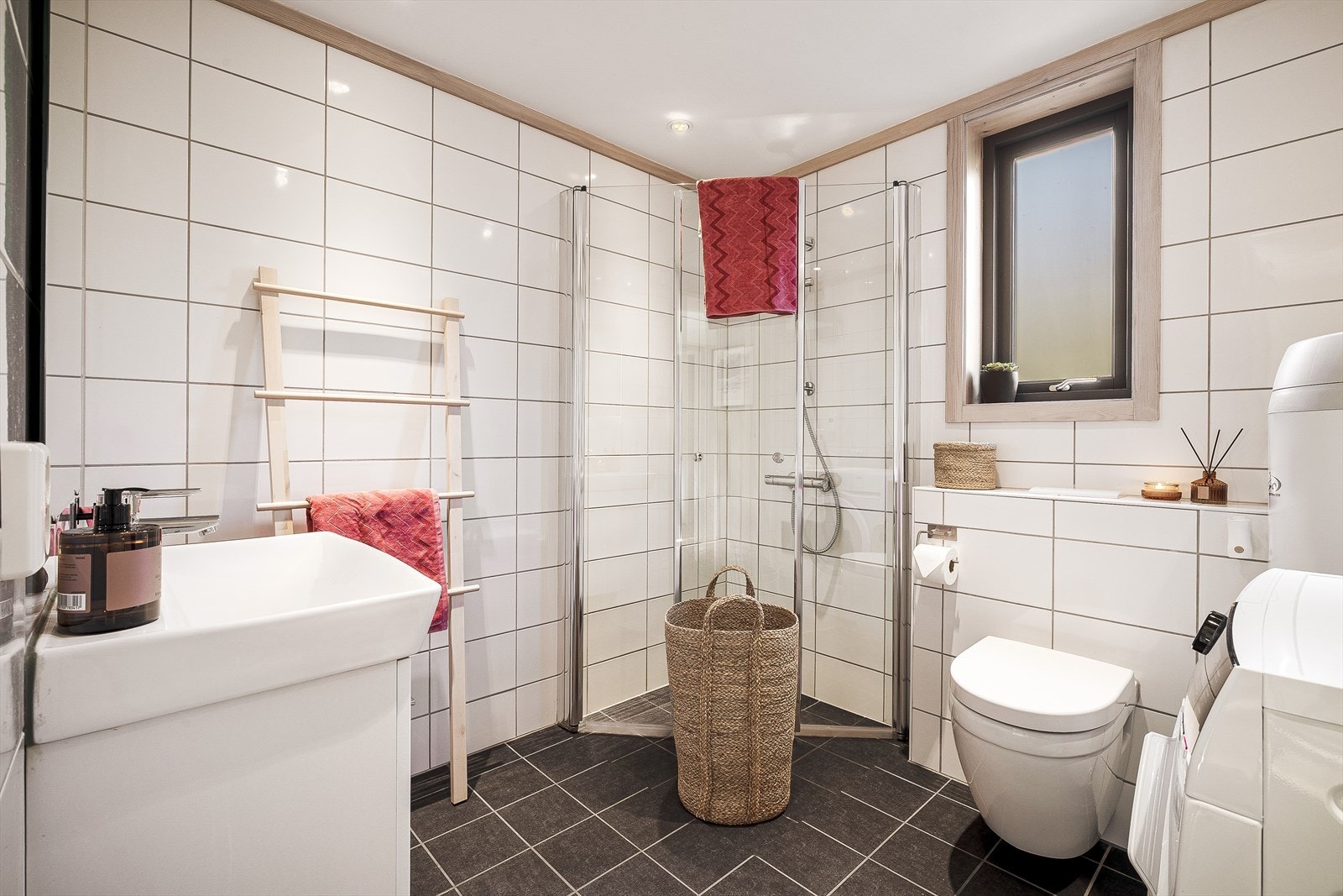 Det stilrene badet er helfliset og utstyrt med vannbåren gulvvarme Galleribilde