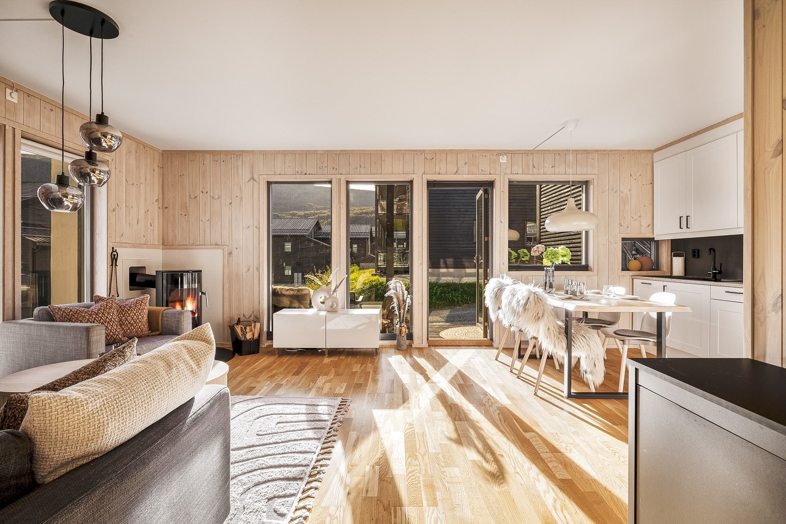 Her er trepanel på veggene, parkettgulv og god plass til både sofagruppe og spisebord Galleribilde