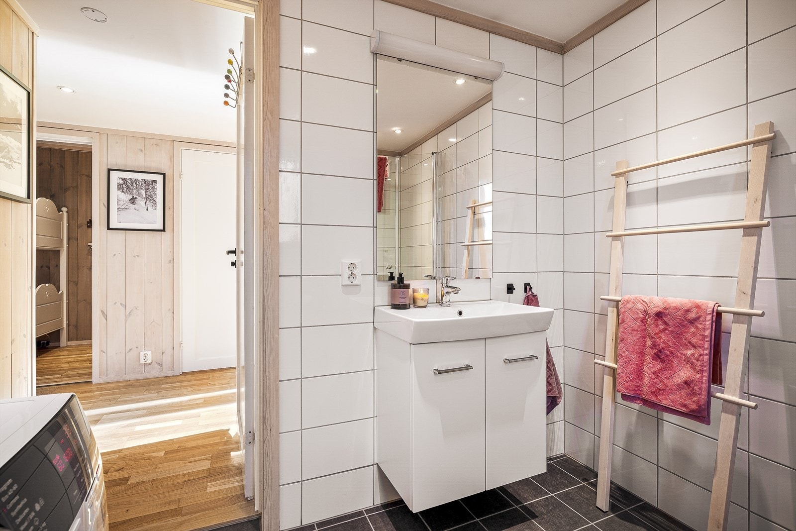 Badet er innredet med dusjhjørne, vegghengt toalett, servant og opplegg for vaskemaskin Galleribilde